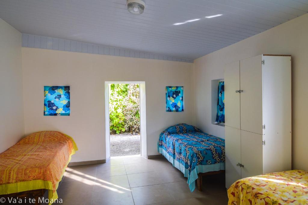um quarto com duas camas e uma porta para um quintal em Va'a i te Moana em Avatoru