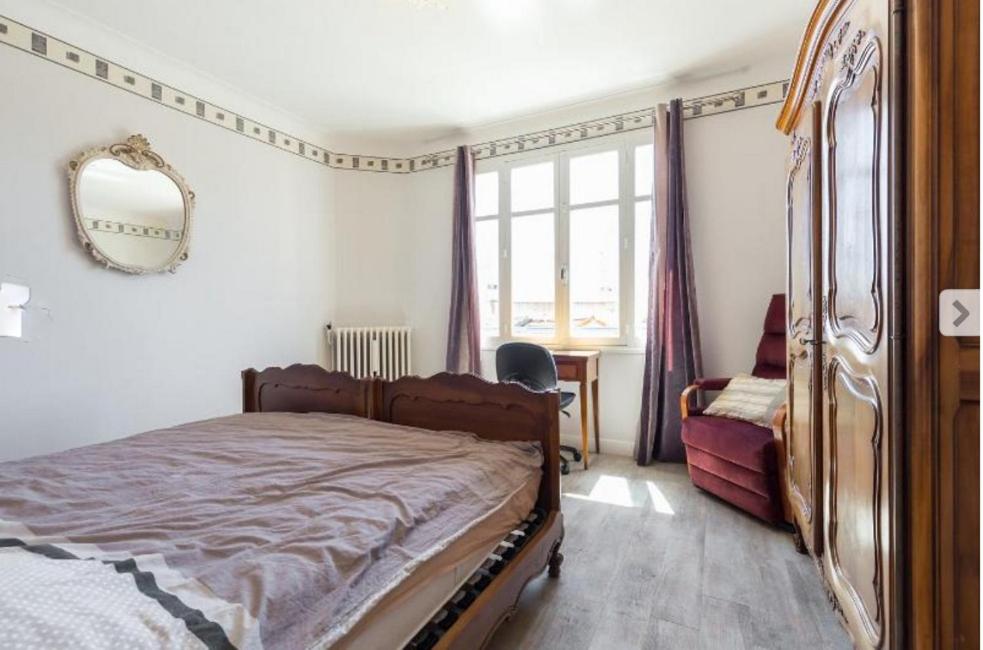 una camera con letto, specchio e finestra di Villa Lerina a Cannes