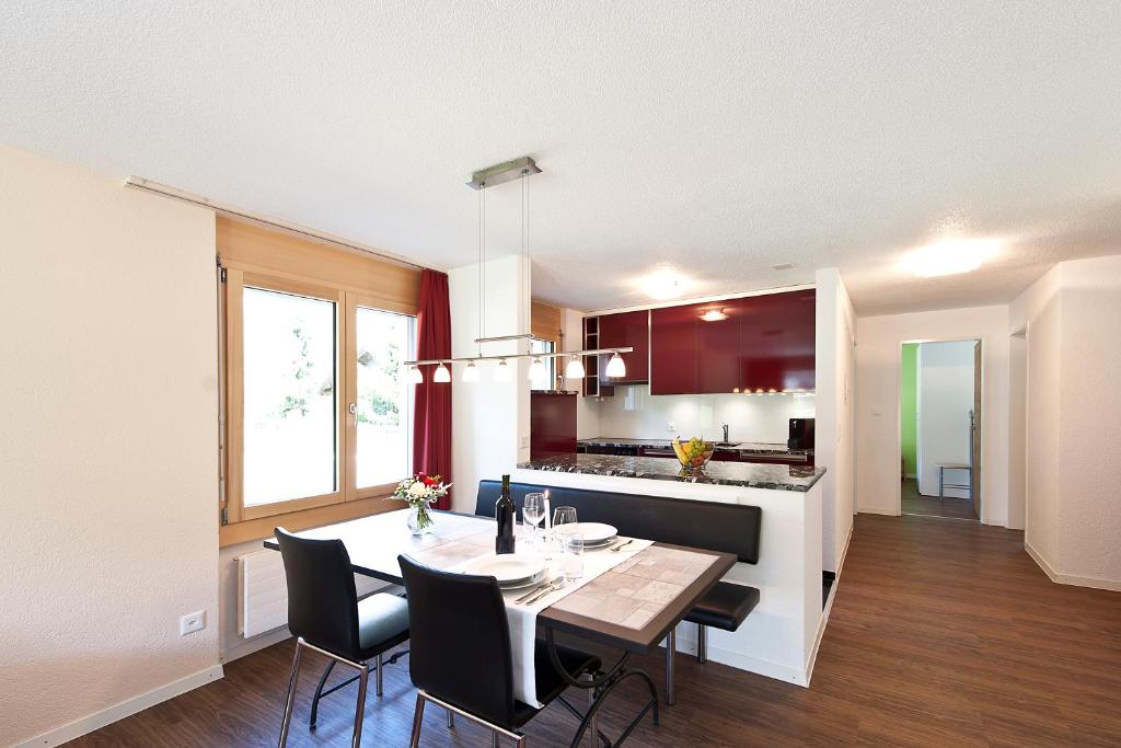 eine Küche und ein Esszimmer mit einem Tisch und Stühlen in der Unterkunft Pollux Family Apartment in Zermatt