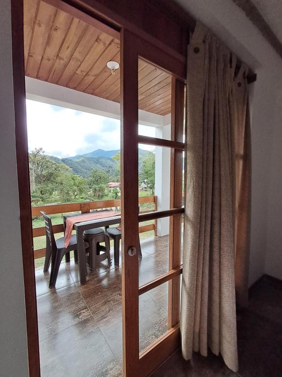 a room with a sliding glass door with a table and bench at BellaVista 2 habitaciones con balcón in Oxapampa