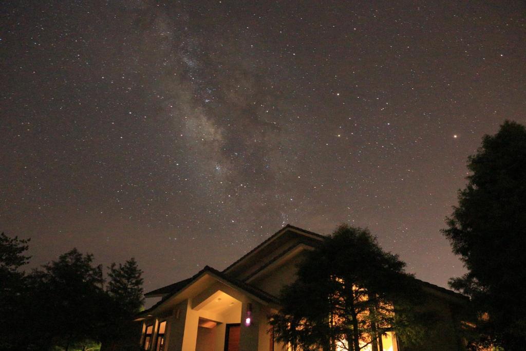 una vista nocturna de la Vía Láctea sobre una casa en Bear Forest Villa en Fengping