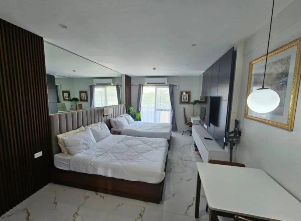 a bedroom with two beds and a tv in it at Kembali Condo Unit For Rent in Magamomo