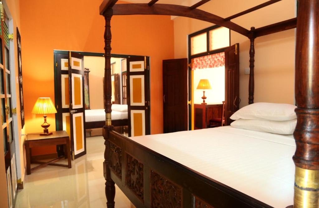 カトゥナーヤカにあるヴィラ セイロンのベッドルーム(天蓋付きベッド1台、鏡付)