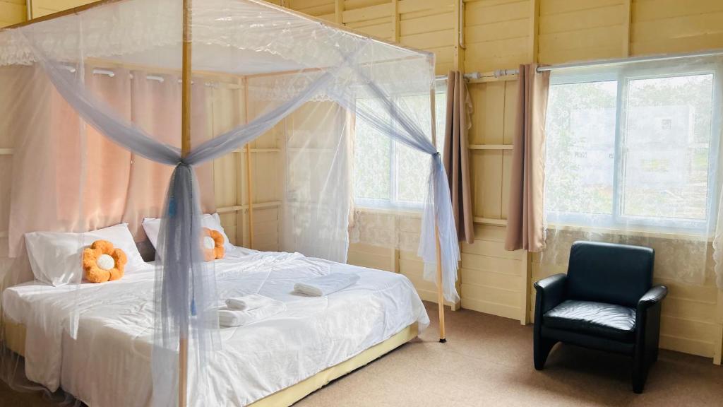 una camera da letto con un letto a baldacchino con una sedia e un orsacchiotto di Garden house 