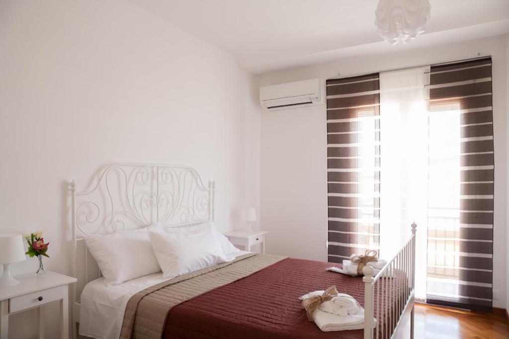 een witte slaapkamer met een bed met een rode deken bij Sui tetti b&b in Alcamo