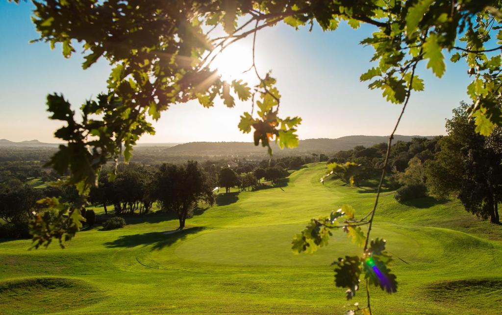 uma vista para um campo de golfe com o sol a brilhar em Le Daya Hotel et Spa em Roquebrune-sur-Argens