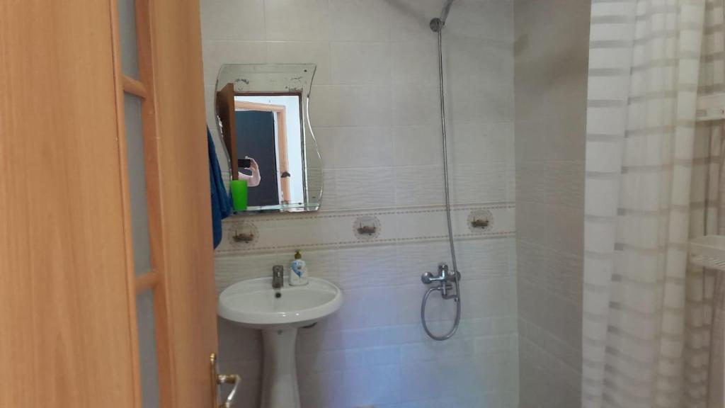 Un baño con lavabo y ducha con espejo. en holiday house, en Ereván