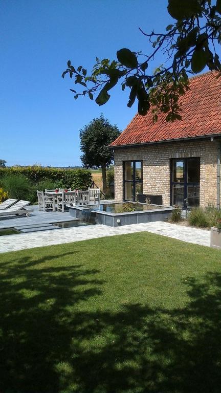 ein Haus mit einer Terrasse mit einem Tisch und Stühlen in der Unterkunft Ateljee Devlaux in Veurne