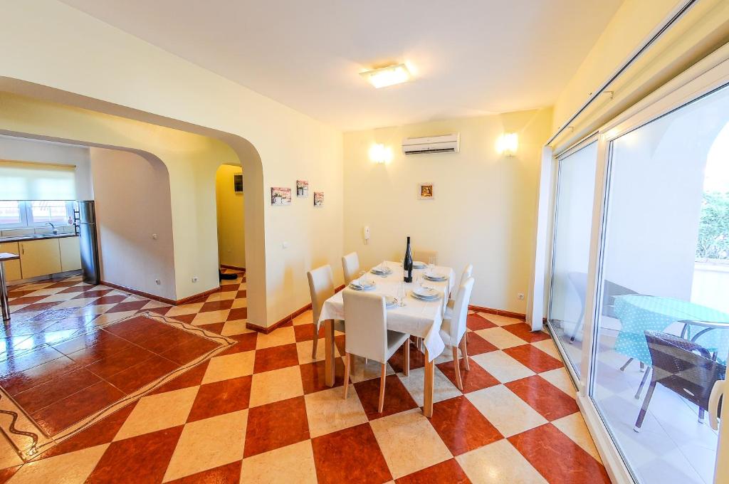comedor con mesa y sillas en un suelo a cuadros en Villa Ana en Split