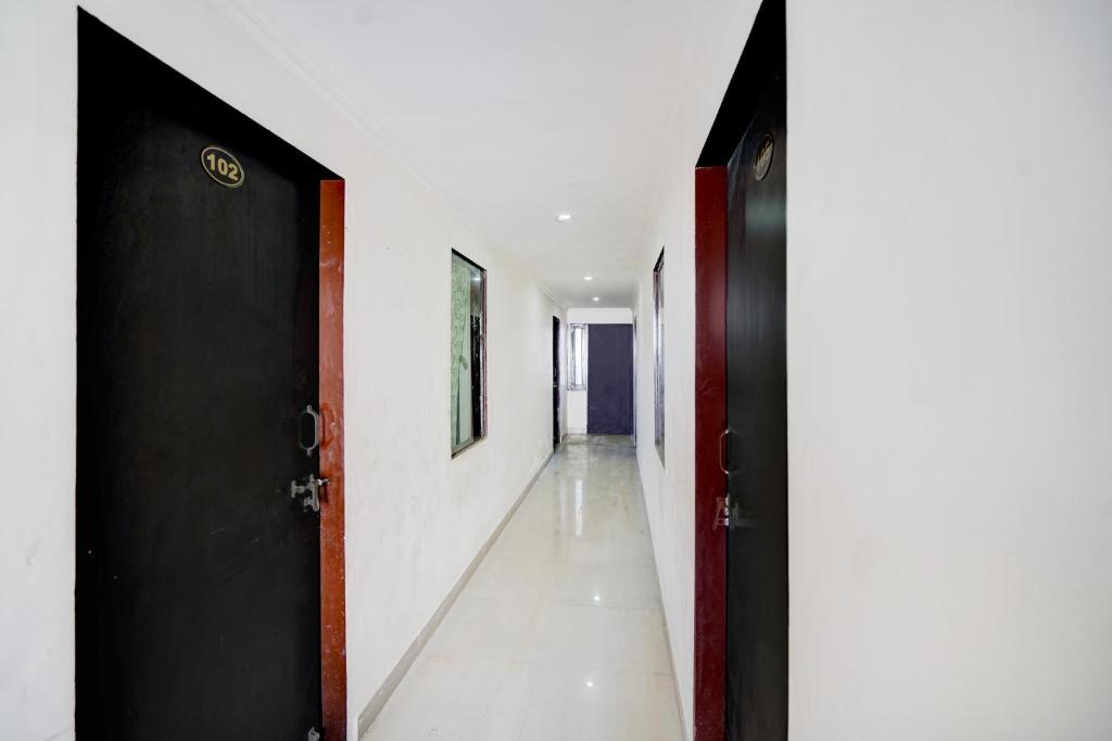 斋浦尔HOTEL O HOLIDAYS INN的走廊上设有两个黑色的门和白色的墙壁