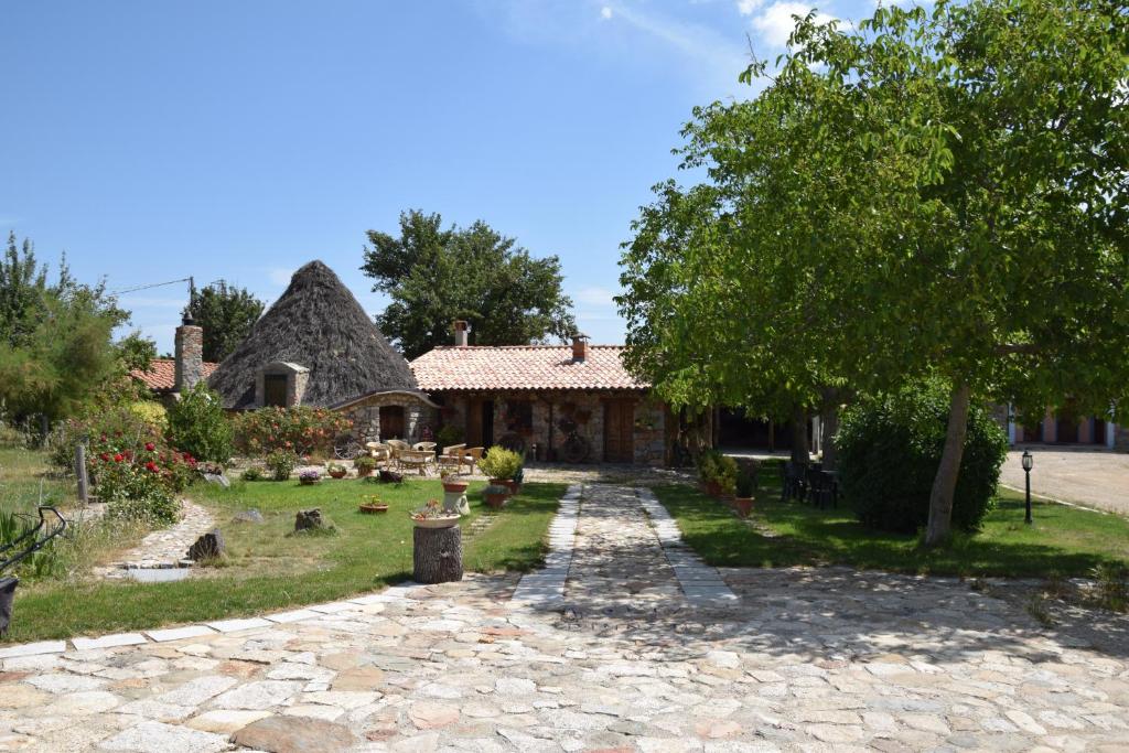 a house with a stone pathway in front of it at Agriturismo Su Pinnettu in Fonni