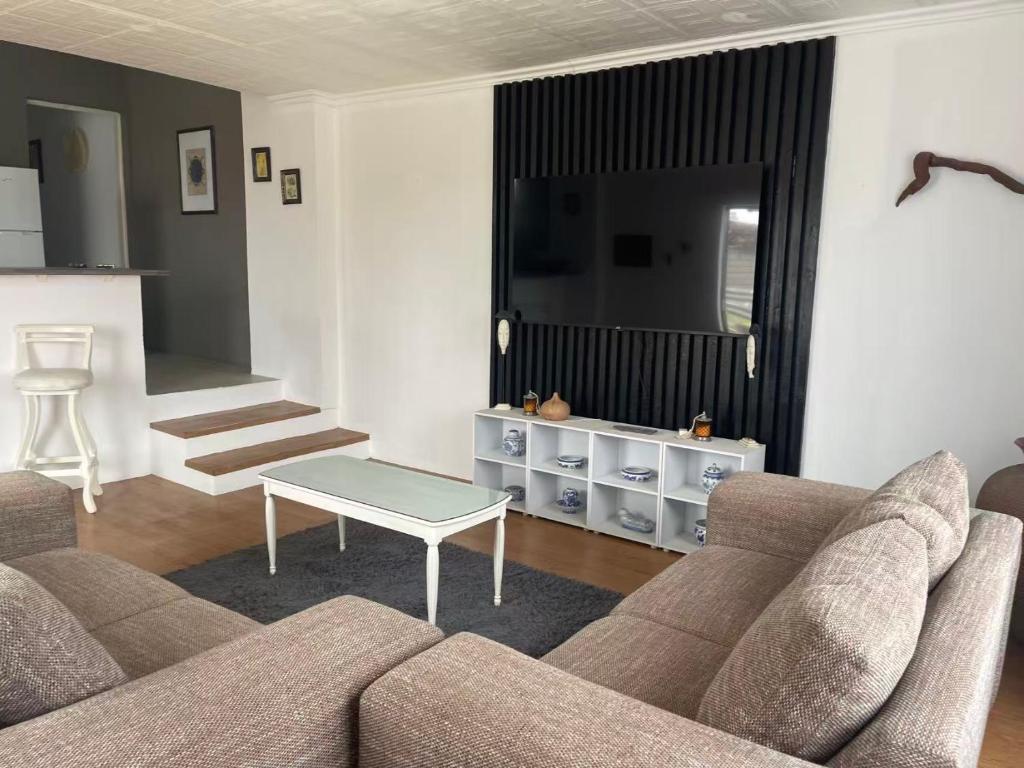 a living room with a couch and a table at Great 2 bedroom home 100m from the beach in Hibberdene