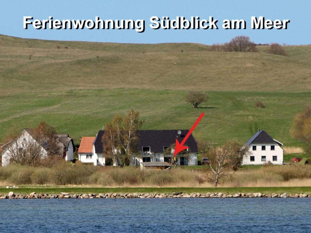 ein Haus auf einem Hügel neben einem Wasserkörper in der Unterkunft Ferienwohnung Südblick am Meer in Groß Zicker