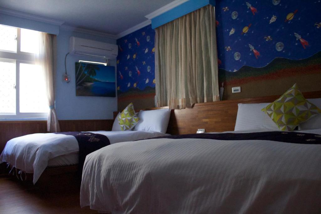two beds in a bedroom with blue walls at 文風小築Wen-Feng House-免費停車 in Kenting