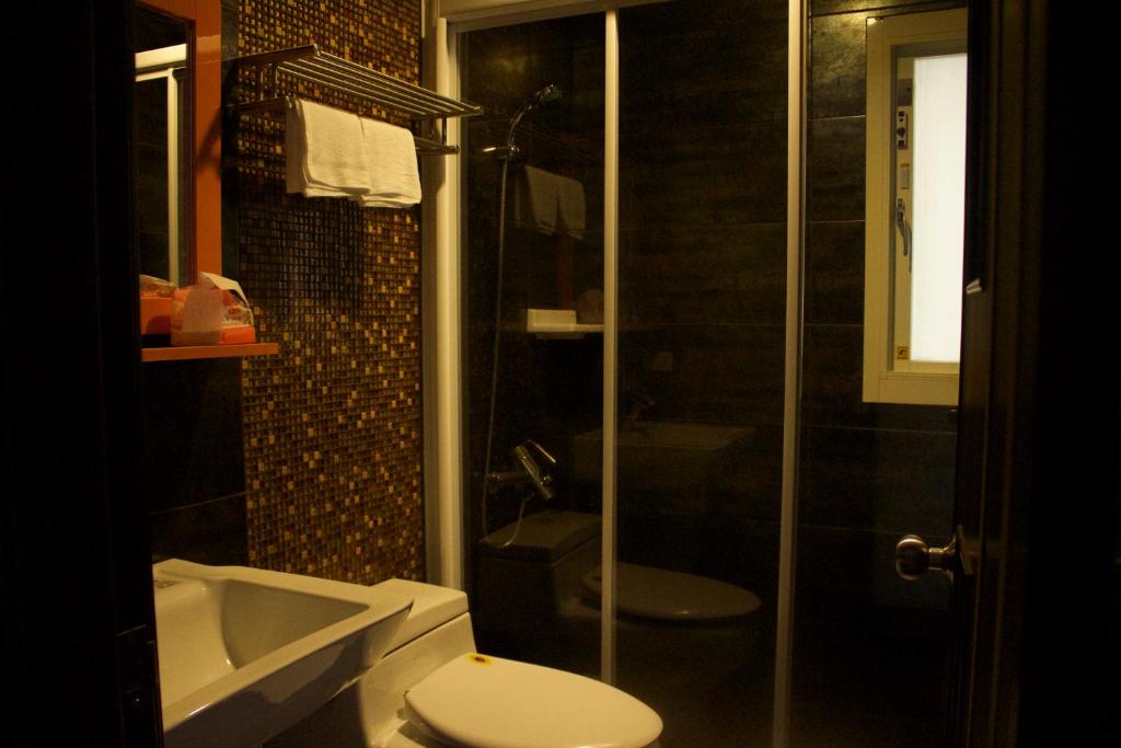 a bathroom with a toilet and a shower and a sink at 文風小築Wen-Feng House-免費停車 in Kenting