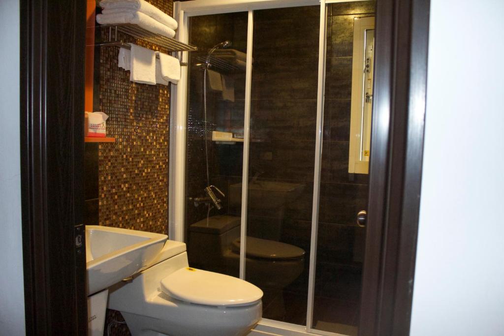 a bathroom with a toilet and a sink and a shower at 文風小築Wen-Feng House-免費停車 in Kenting