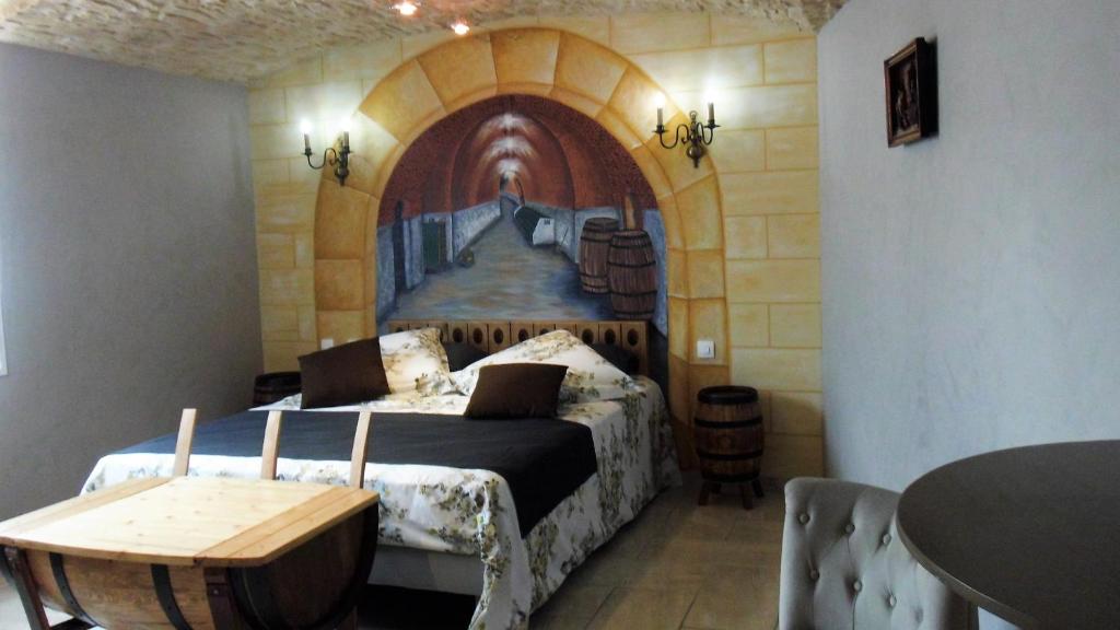 MardeuilにあるPassion Et Terroirのベッドルーム1室(壁に絵画が描かれたベッド1台付)