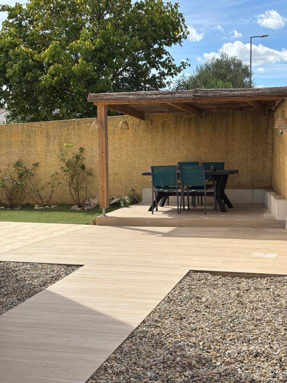 a patio with a table and chairs on it at Villa Familiale 3 Chambres avec Terrasse in Vergèze
