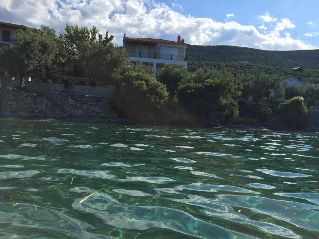 un cuerpo de agua con una casa en el fondo en Villas Nies en Soúrpi