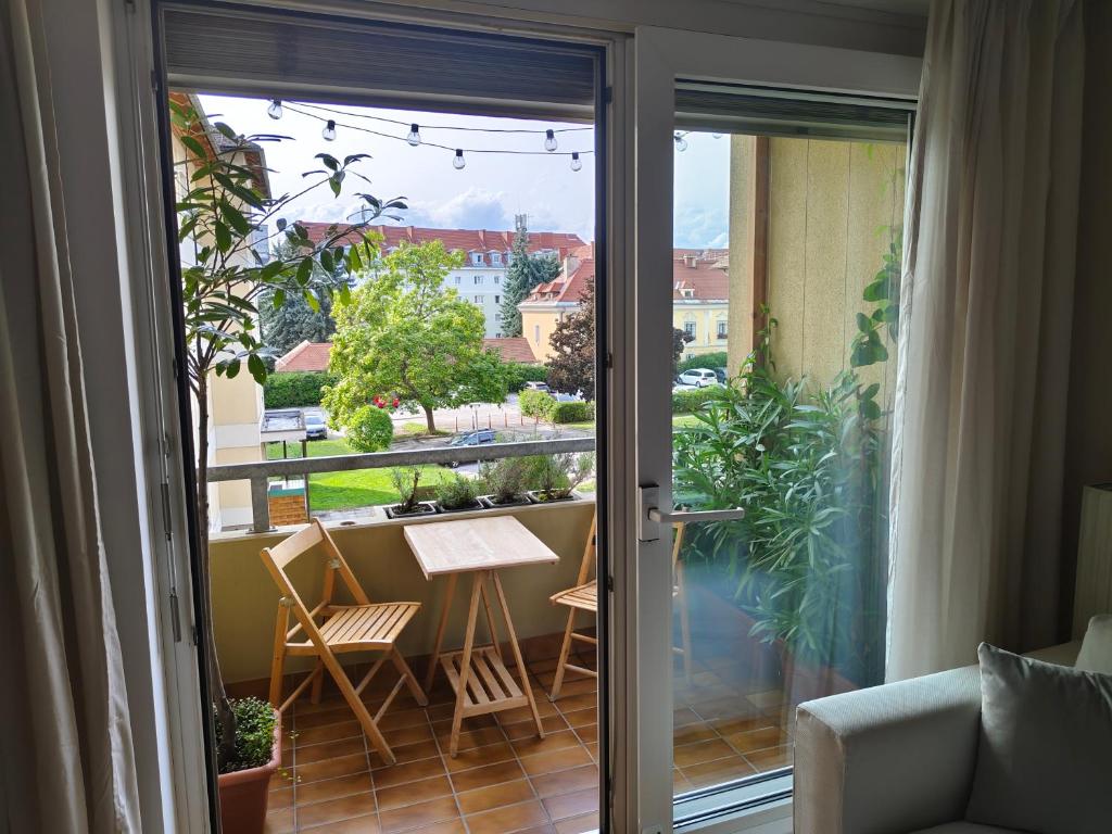a balcony with a table and chairs on a patio at Grünerbalkon Ferienappartement in Klagenfurt