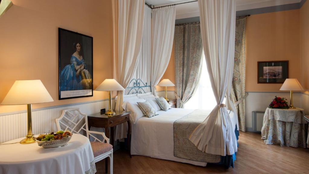 ein Schlafzimmer mit einem Bett und einem Tisch mit einer Schale Obst in der Unterkunft Hotel Victoria & Iside Spa in Turin