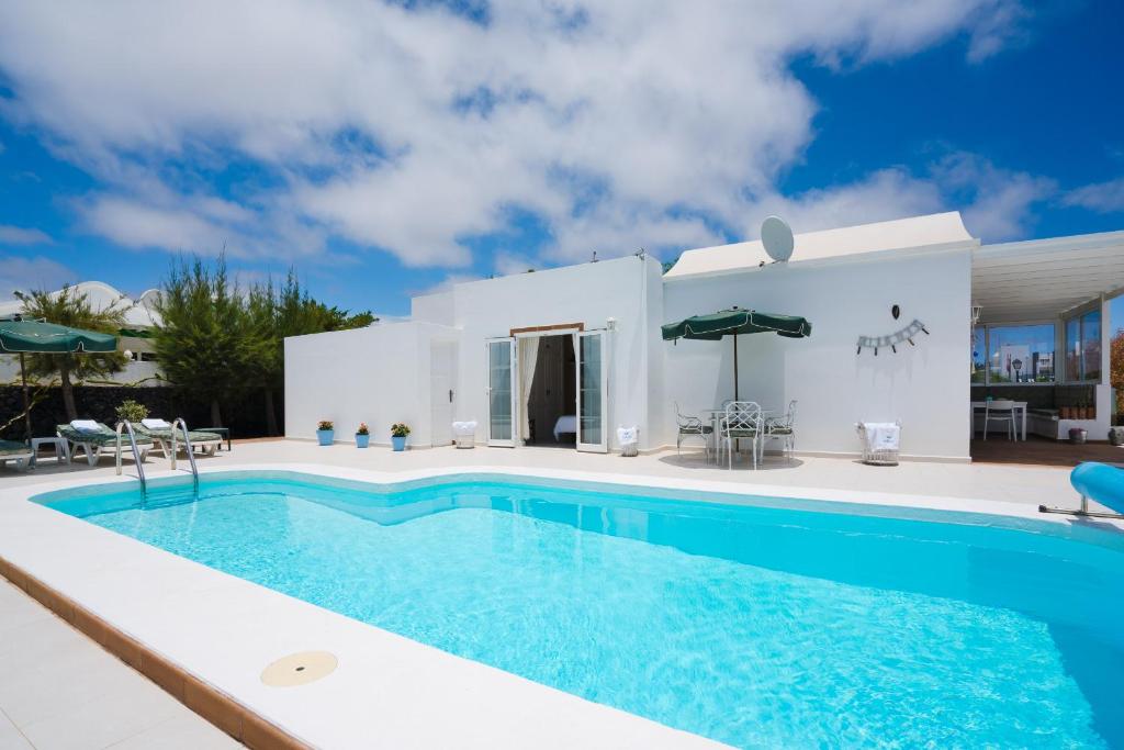 a villa with a swimming pool in front of a house at Villa Pippa in Puerto del Carmen