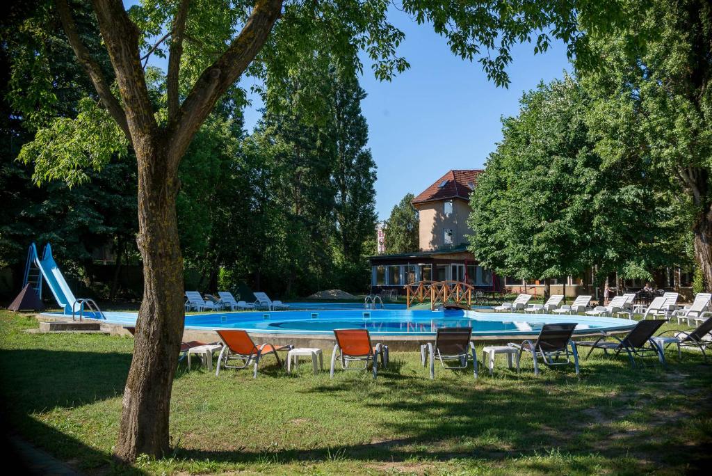 una piscina con sillas y un tobogán en Wellness Hotel Szindbád, en Balatonszemes