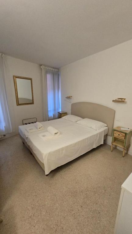 a bedroom with a large white bed in a room at Venice Heart Rooms in Venice