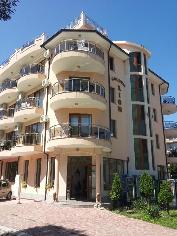 a large building with a dog in front of it at Family Hotel Golden Lion in Primorsko