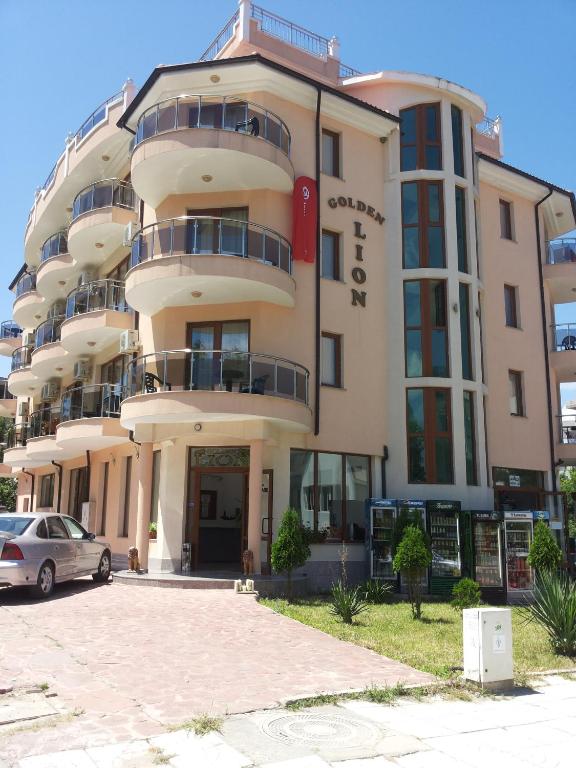 a building with a car parked in front of it at Family Hotel Golden Lion in Primorsko