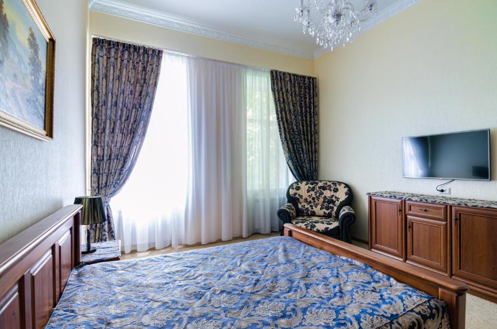 Pokój z łóżkiem, telewizorem i krzesłem w obiekcie Apartamenty Kulisha 25 w Lwowie