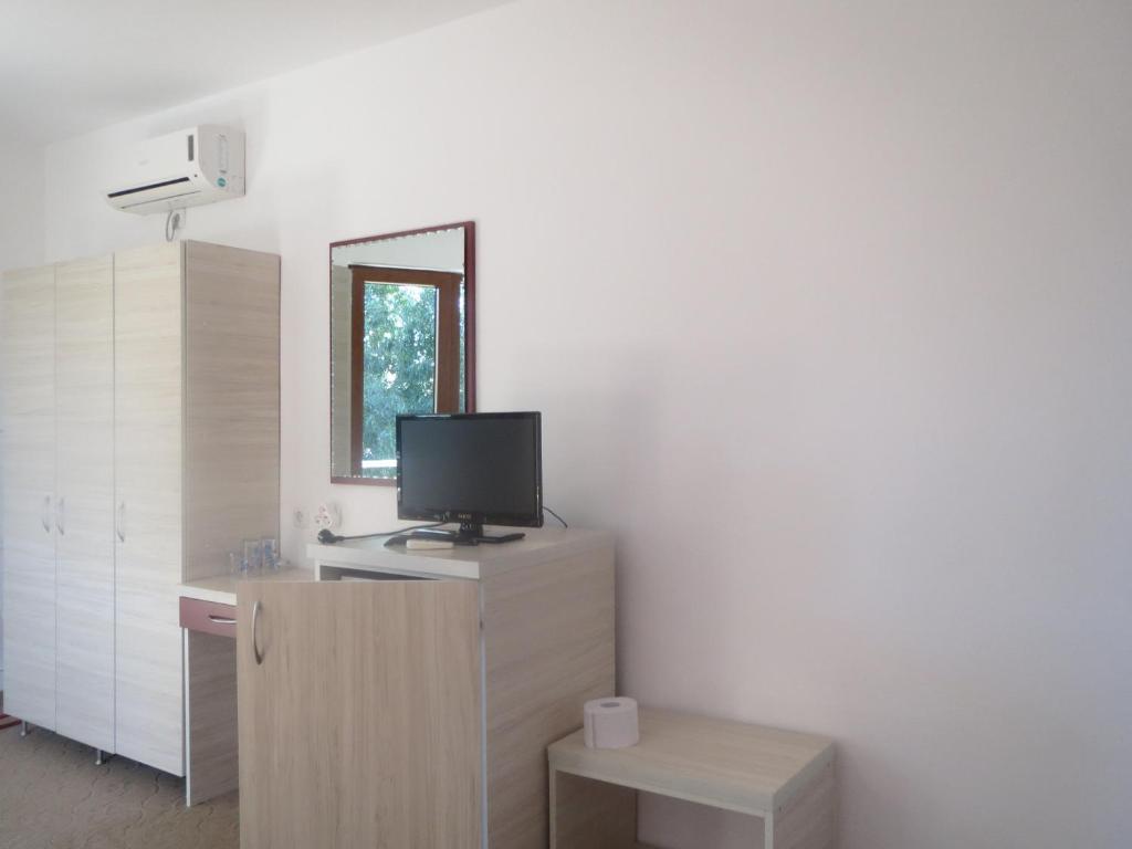 a living room with a tv on top of a cabinet at Family Hotel Golden Lion in Primorsko