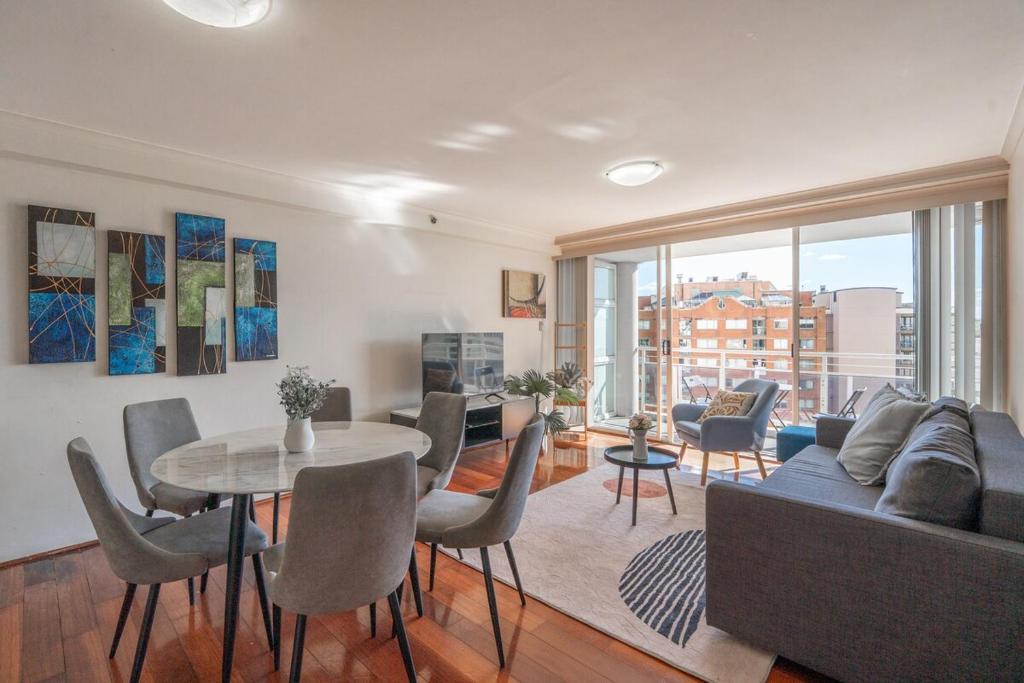 a living room with a couch and a table and chairs at Cosmopolitan Charm in Central Sydney in Sydney