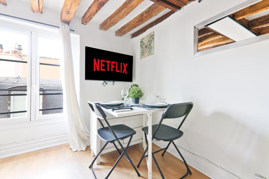 un tavolo bianco e sedie in una stanza con una finestra di Studio Quartier Saint-Michel Notre-Dame 4 Free Netflix a Parigi