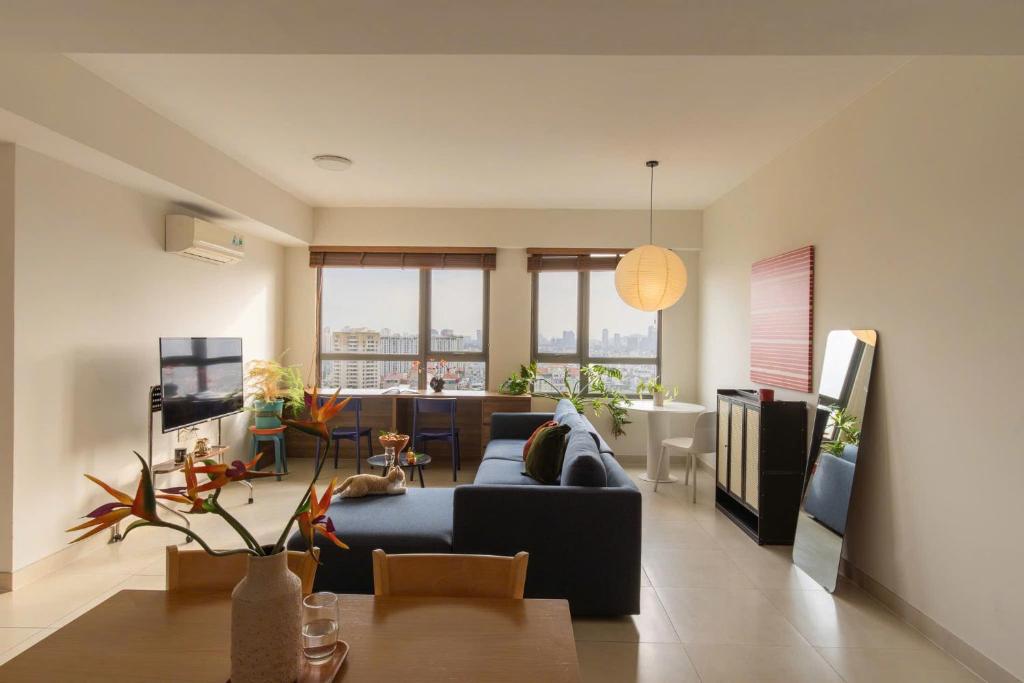 a living room with a blue couch and a table at The Vista Masteri Thao Dien N-Stay Apartment in Ho Chi Minh City