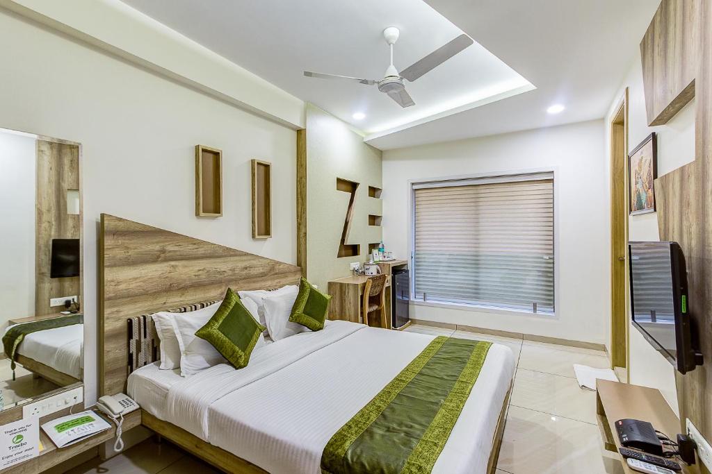 印多爾的住宿－Treebo Trend Daksh Residency，一间卧室配有一张大床和电视
