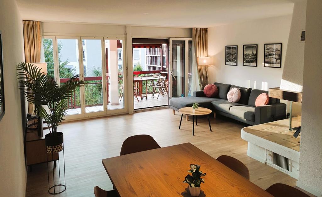 a living room with a couch and a table at Top duplex Apartment Zurich-Limmattal in Killwangen