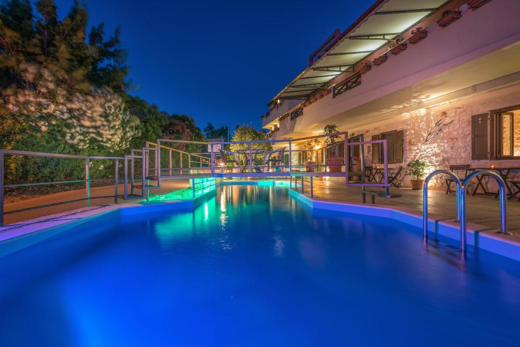 a swimming pool in a house at night at Dante's Maisonettes in Amoudi
