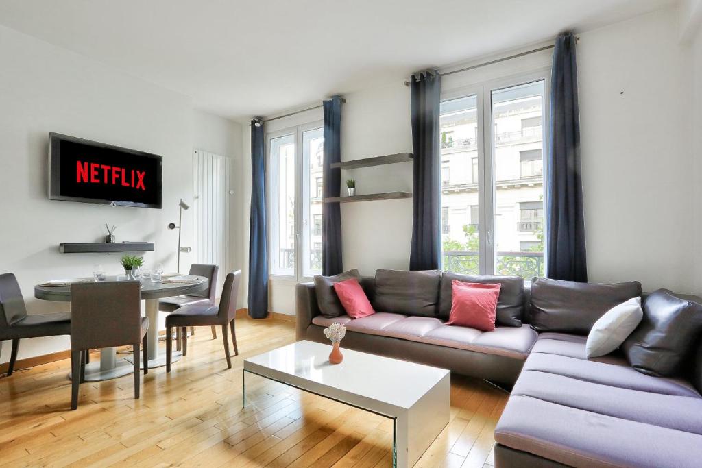 een woonkamer met een bank en een tafel bij Appartement Quartier Champs-Élysées 4 Free Netflix in Parijs