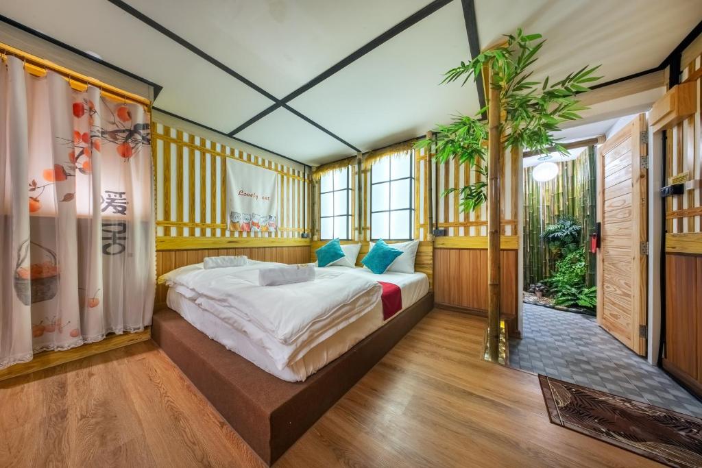 a bedroom with a bed and a plant in it at SHIN Hotel 80th Stadium Korat in Sathani Phu Khao Lat