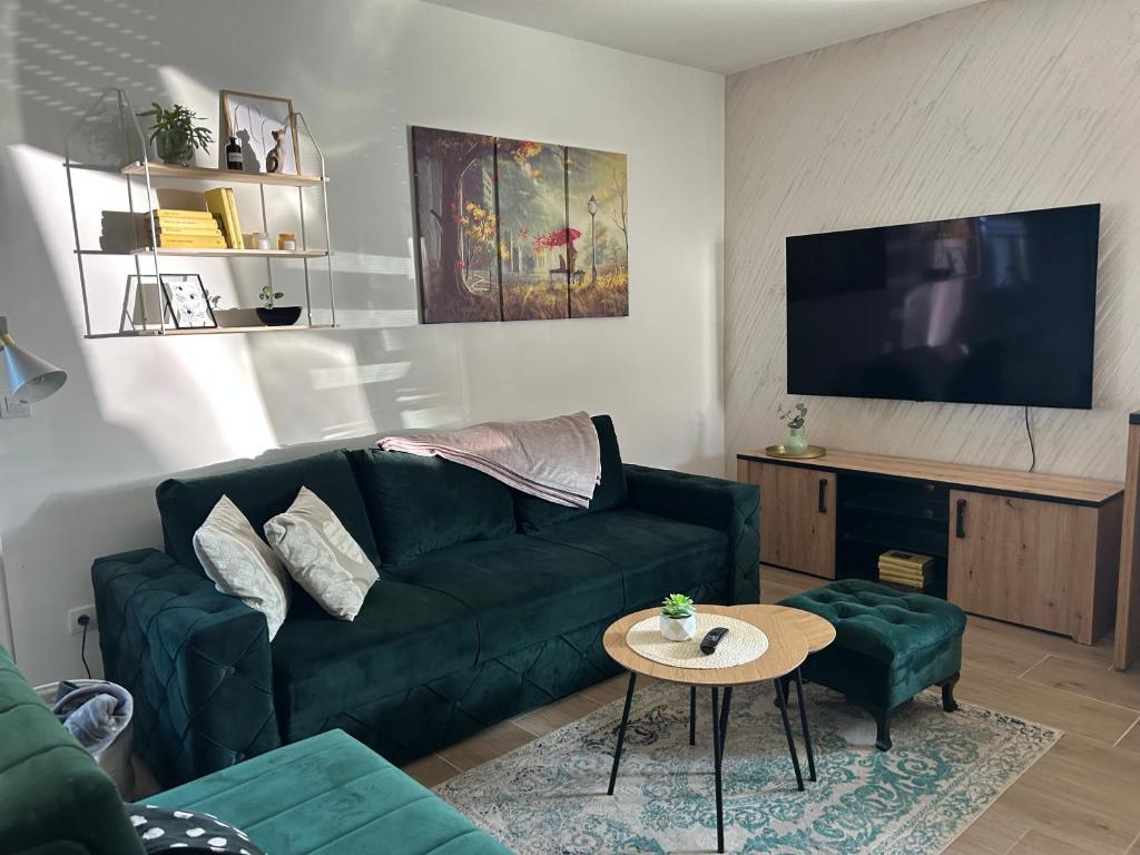 a living room with a green couch and a table at Snowlake in Divčibare