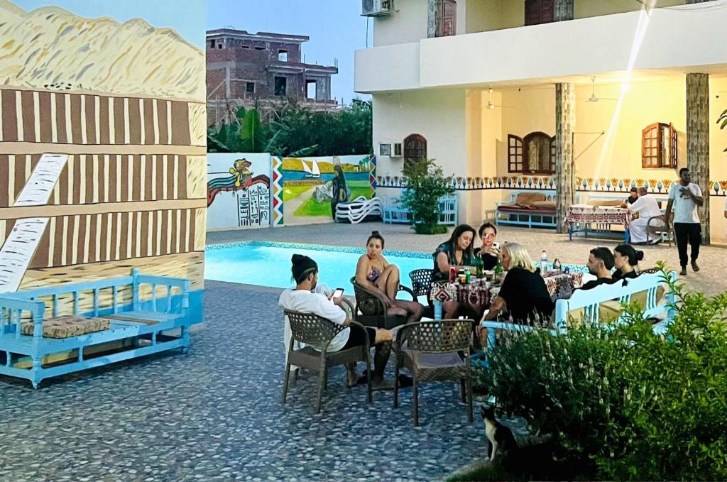 a group of people sitting at tables near a pool at Luxor Hotel in Luxor
