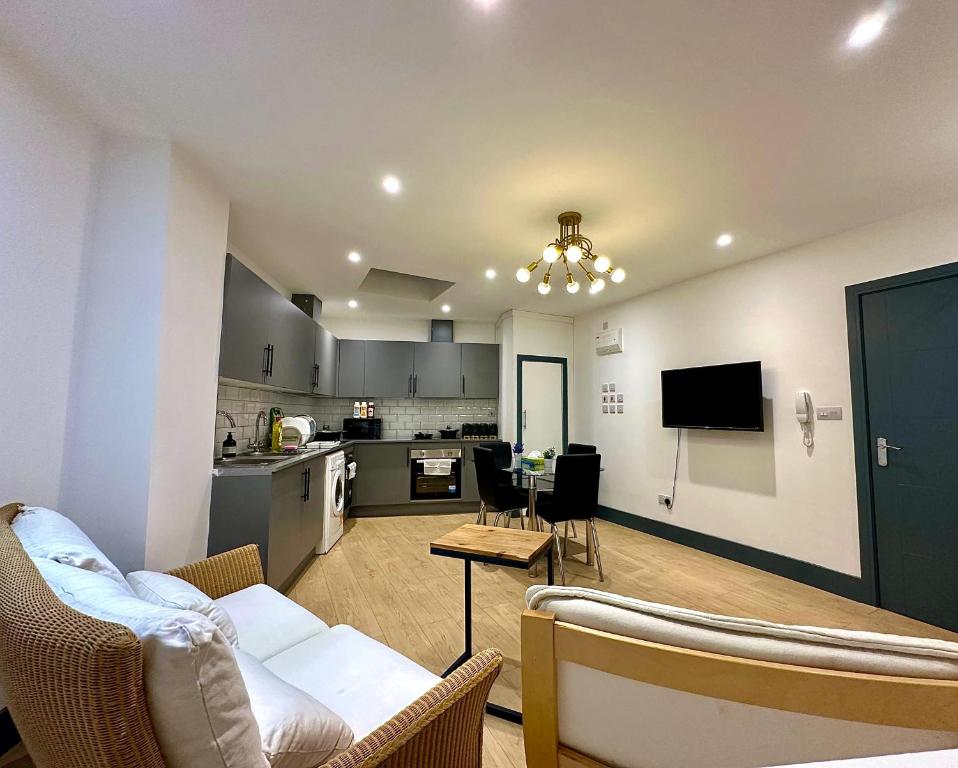 a living room with a couch and a kitchen at Stylish Ensuit Studios in the Heart of Vibrant Tooting 1 Min to Tube in London