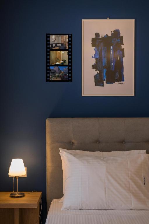 a bedroom with a blue wall with a bed and a lamp at Mirma City apartment2 Old Town in Chania