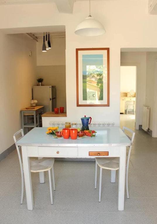 a kitchen with a white table and chairs in a room at da Roy in Scansano