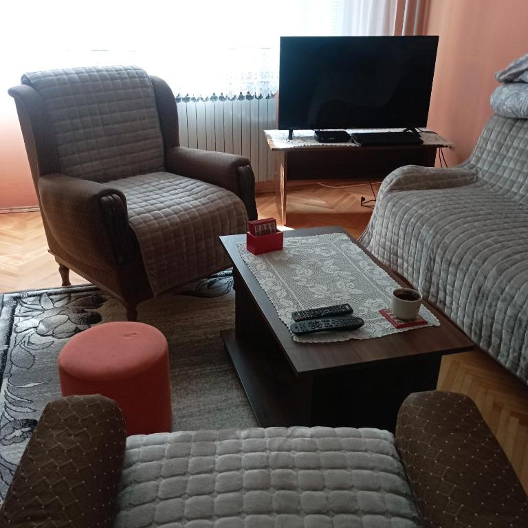 a living room with two chairs and a tv at Apartman Icić in Pirot