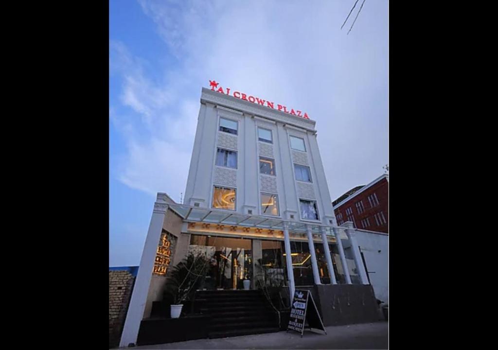 a tall building with a sign on top of it at Hotel Taj Crown Plaza - By BS Group Of Hotels in Agra