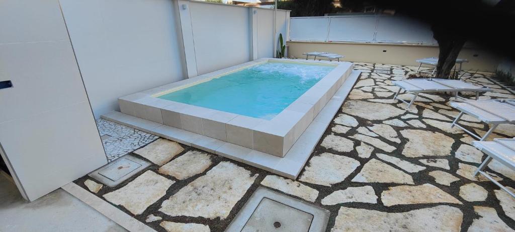 una grande piscina con due sedie e un tavolo di Affittacamere mezzaluna a San Benedetto del Tronto