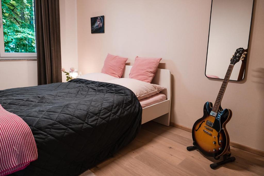 a bedroom with a guitar next to a bed at Anubis relaxed&stay in Hamburg