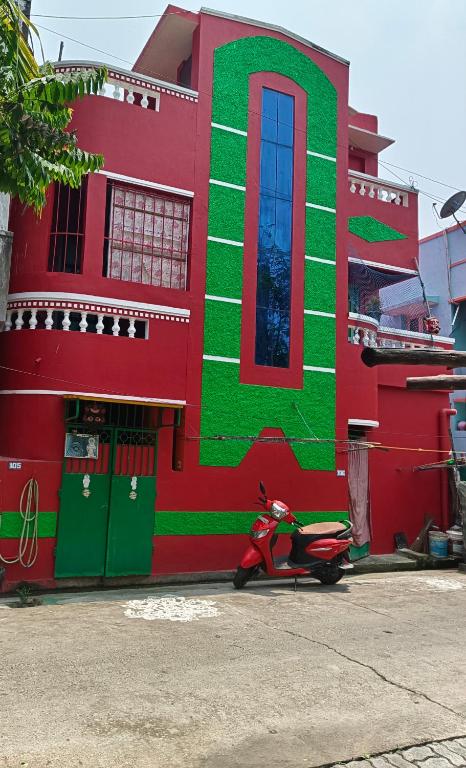 a red and green building with a scooter parked in front at BlueWaves in Pondicherry